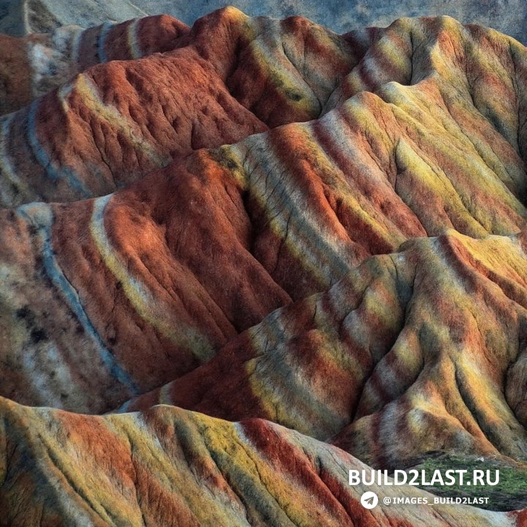 Пейзаж разноцветных гор в Китае с оттенками желтого, красного и оранжевого.